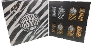 Packaging with zebra pattern and 'TJOFE' branding, featuring small items inside.